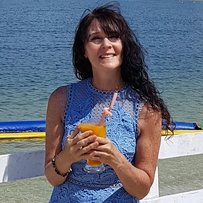 Jenette McFadzen, The Cotswolds Juice Retreat's detox and wellness guide, smiling and holding a fresh juice